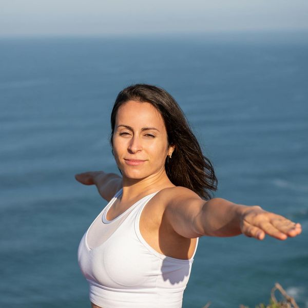 Person in a calm stretching pose against a sky blue background.